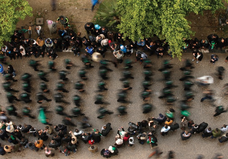 PEOPLE WATCH as Palestinian members of al-Qassam Brigades parade in Gaza. (photo credit:REUTERS)