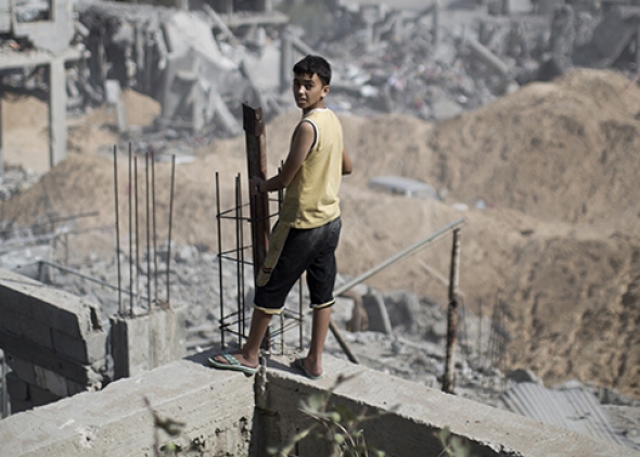 A Palestinian youth looks out at the destruction in part of Gaza City's al-Tufah neighborhood on Wednesday during the cease-fire. Photo by Mahmud Hams/AFP/Getty Images