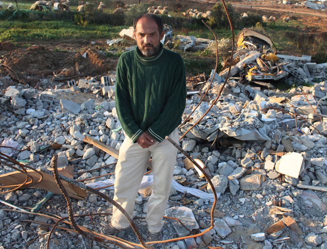 Raid el Atmnah, 37, stands in rubble that used to be his home in Gaza. He was ordered to leave and returned to find the rubble.