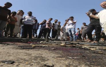 Gaza Palestinians survey the wreckage of an IAF strike that killed two terrorists in Gaza. Photo: REUTERS